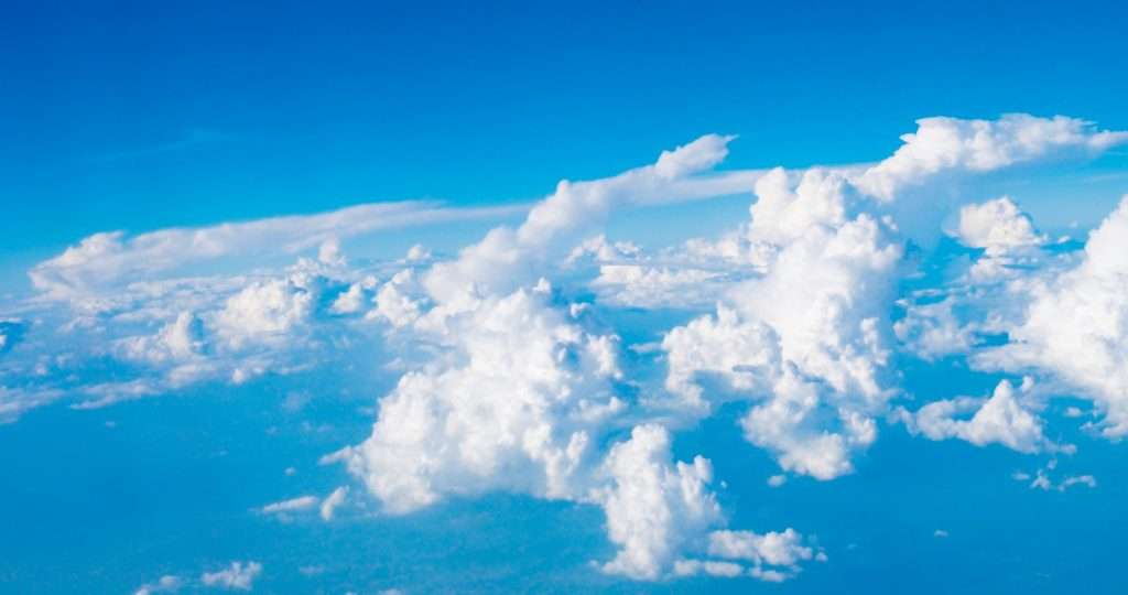 Blue sky with clouds and sun on airplane view