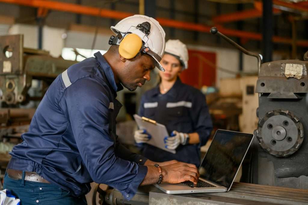 Male technician specialist with safety uniform using laptop